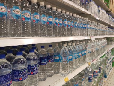Kuala Lumpur, Malezya - 26 Ekim 2019: Maden suyu paketlendi ve plastik şişelerde çeşitli markalarla etiketlendi. Süpermarketin içindeki bir rafta gösteriliyor.