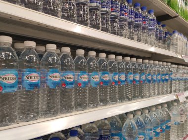Kuala Lumpur, Malezya - 26 Ekim 2019: Maden suyu paketlendi ve plastik şişelerde çeşitli markalarla etiketlendi. Süpermarketin içindeki bir rafta gösteriliyor.