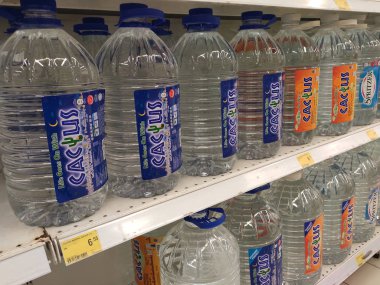Kuala Lumpur, Malezya - 26 Ekim 2019: Maden suyu paketlendi ve plastik şişelerde çeşitli markalarla etiketlendi. Süpermarketin içindeki bir rafta gösteriliyor.