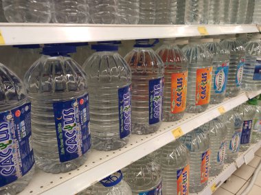 Kuala Lumpur, Malezya - 26 Ekim 2019: Maden suyu paketlendi ve plastik şişelerde çeşitli markalarla etiketlendi. Süpermarketin içindeki bir rafta gösteriliyor.
