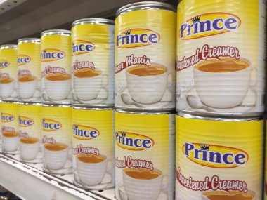 Kuala Lumpur, Malezya - 22 Aralık 2019: Şekerli krema ve buharlaştırılmış süt kutular içinde paketlenmiş ve süpermarketin içindeki rafta satılmak üzere sergilenmektedir. Ana bileşen palmiye yağı tohumlarından yapılır..