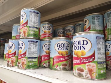 Kuala Lumpur, Malezya - 22 Aralık 2019: Şekerli krema ve buharlaştırılmış süt kutular içinde paketlenmiş ve süpermarketin içindeki rafta satılmak üzere sergilenmektedir. Ana bileşen palmiye yağı tohumlarından yapılır..