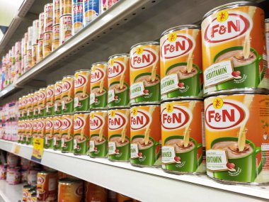 Kuala Lumpur, Malezya - 22 Aralık 2019: Şekerli krema ve buharlaştırılmış süt kutular içinde paketlenmiş ve süpermarketin içindeki rafta satılmak üzere sergilenmektedir. Ana bileşen palmiye yağı tohumlarından yapılır..