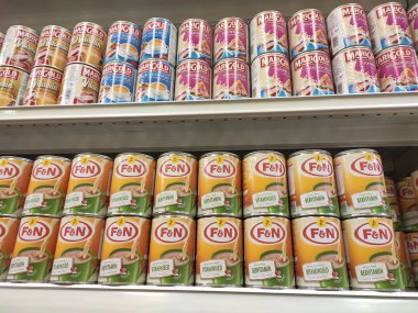 Kuala Lumpur, Malezya - 22 Aralık 2019: Şekerli krema ve buharlaştırılmış süt kutular içinde paketlenmiş ve süpermarketin içindeki rafta satılmak üzere sergilenmektedir. Ana bileşen palmiye yağı tohumlarından yapılır..