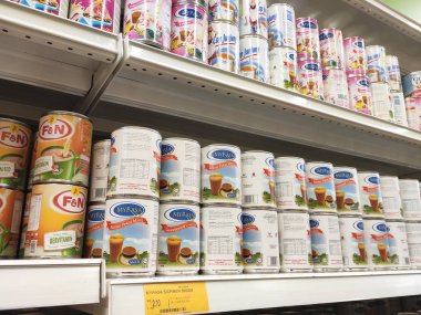Kuala Lumpur, Malezya - 22 Aralık 2019: Şekerli krema ve buharlaştırılmış süt kutular içinde paketlenmiş ve süpermarketin içindeki rafta satılmak üzere sergilenmektedir. Ana bileşen palmiye yağı tohumlarından yapılır..