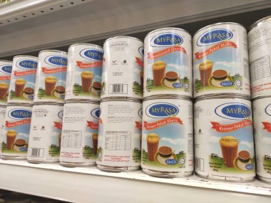 Kuala Lumpur, Malezya - 22 Aralık 2019: Şekerli krema ve buharlaştırılmış süt kutular içinde paketlenmiş ve süpermarketin içindeki rafta satılmak üzere sergilenmektedir. Ana bileşen palmiye yağı tohumlarından yapılır..
