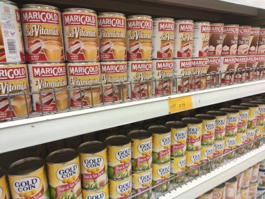 Kuala Lumpur, Malezya - 22 Aralık 2019: Şekerli krema ve buharlaştırılmış süt kutular içinde paketlenmiş ve süpermarketin içindeki rafta satılmak üzere sergilenmektedir. Ana bileşen palmiye yağı tohumlarından yapılır..