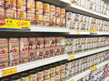 Kuala Lumpur, Malezya - 22 Aralık 2019: Şekerli krema ve buharlaştırılmış süt kutular içinde paketlenmiş ve süpermarketin içindeki rafta satılmak üzere sergilenmektedir. Ana bileşen palmiye yağı tohumlarından yapılır..
