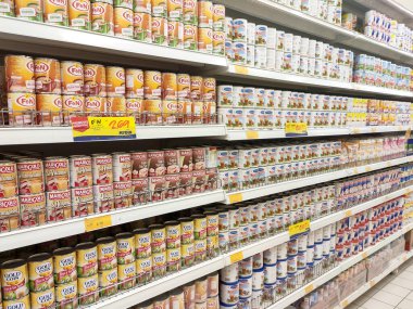 Kuala Lumpur, Malezya - 22 Aralık 2019: Şekerli krema ve buharlaştırılmış süt kutular içinde paketlenmiş ve süpermarketin içindeki rafta satılmak üzere sergilenmektedir. Ana bileşen palmiye yağı tohumlarından yapılır..