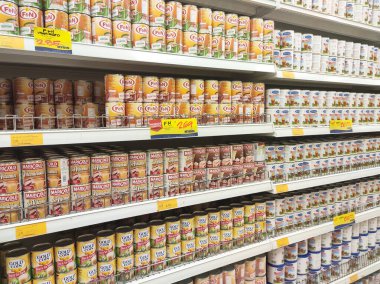 Kuala Lumpur, Malezya - 22 Aralık 2019: Şekerli krema ve buharlaştırılmış süt kutular içinde paketlenmiş ve süpermarketin içindeki rafta satılmak üzere sergilenmektedir. Ana bileşen palmiye yağı tohumlarından yapılır..