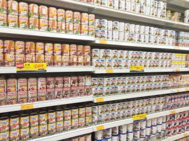 Kuala Lumpur, Malezya - 22 Aralık 2019: Şekerli krema ve buharlaştırılmış süt kutular içinde paketlenmiş ve süpermarketin içindeki rafta satılmak üzere sergilenmektedir. Ana bileşen palmiye yağı tohumlarından yapılır..