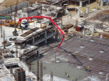 Kuala Lumpur, Malezya - 28 Ağustos 2019: İnşaat işçilerinin inşaat alanında somut çalışmaları. Dökülen yere ıslak beton taşımak için kullanılan ağır makineler.. 