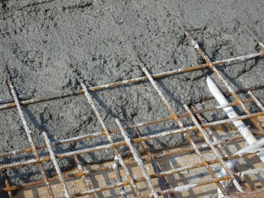 Çelik takviye çubuğuna dökülen ıslak beton zemini güçlendirmek için beton levhalar oluşturdu.. 