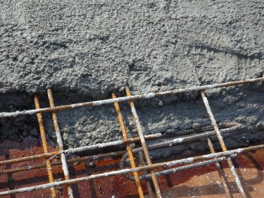 Çelik takviye çubuğuna dökülen ıslak beton zemini güçlendirmek için beton levhalar oluşturdu.. 