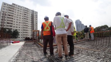 Kuala Lumpur, Malezya - 07 Nisan 2019: İnşaat işçileri inşaat alanında teknik sorunlar hakkında kendi aralarında tartıştılar. 