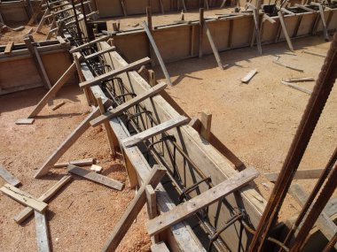 İnşaat halindeki zemin kirişini inşaat alanında geçici kereste kontrplak kullanarak inşa ediyoruz. Yapıyı güçlendirmek için güçlendirilmiş çelik..   