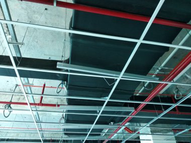 Kuala Lumpur, Malezya - 7 Nisan 2018: Klima kanalı ve soğutucu boru sistemi kurulumu ve beton levhaya asılması. Diğer hizmetlerle birlikte yüklendi ve koordine edildi. 