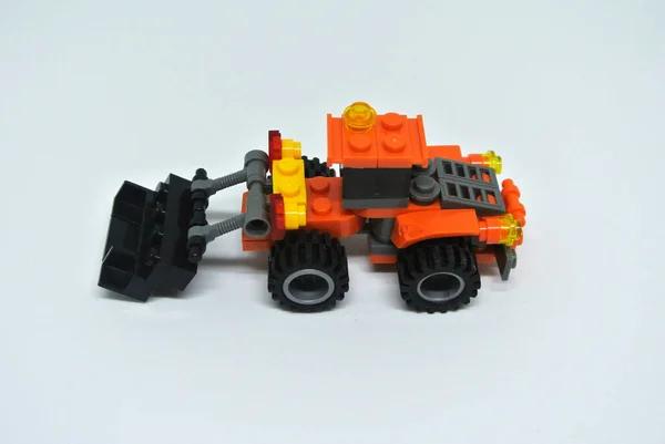 玩具推土机主要由橙色和黑色塑料砖制成 被白色背景隔离 — 图库照片