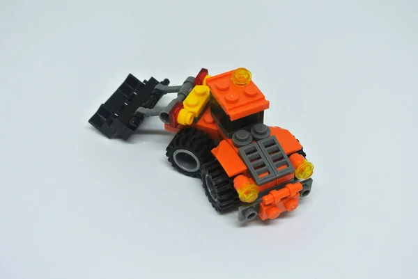 Hračkový Buldozer Vyrobený Převážně Oranžových Černých Plastových Cihel Izolováno Bílém — Stock fotografie
