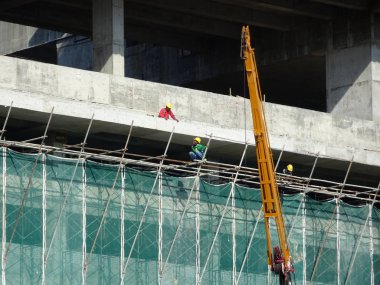 Kuala Lumpur, Malezya - 6 Haziran 2016: İnşaat altındaki binanın dış kısmına inşaat enkazının düşmesini önlemek için plastik veya naylon ağ örüldü. Geçici kurulum.