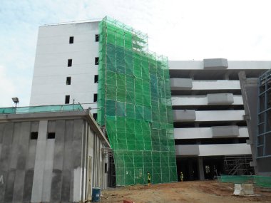 Kuala Lumpur, Malezya - 6 Haziran 2016: İnşaat altındaki binanın dış kısmına inşaat enkazının düşmesini önlemek için plastik veya naylon ağ örüldü. Geçici kurulum.