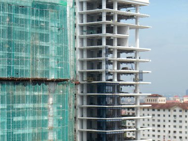 Kuala Lumpur, Malezya - 6 Haziran 2016: İnşaat altındaki binanın dış kısmına inşaat enkazının düşmesini önlemek için plastik veya naylon ağ örüldü. Geçici kurulum.