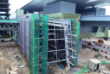 Kuala Lumpur, Malezya - 6 Haziran 2016: İnşaat altındaki binanın dış kısmına inşaat enkazının düşmesini önlemek için plastik veya naylon ağ örüldü. Geçici kurulum.