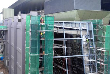 Kuala Lumpur, Malezya - 6 Haziran 2016: İnşaat altındaki binanın dış kısmına inşaat enkazının düşmesini önlemek için plastik veya naylon ağ örüldü. Geçici kurulum.