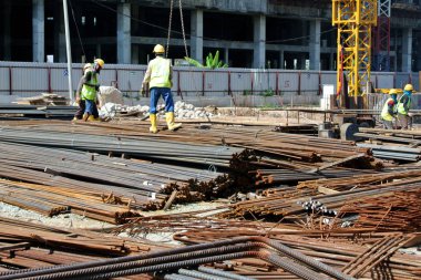 Kuala Lumpur, Malezya - 4 Ağustos 2017: İnşaat alanındaki çelik takviyeli bar bükme alanında çalışan inşaat işçileri. Bükme makinesini kullanarak demiri bükmek. 