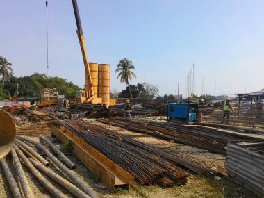 Kuala Lumpur, Malezya - 4 Ağustos 2017: İnşaat alanındaki çelik takviyeli bar bükme alanında çalışan inşaat işçileri. Bükme makinesini kullanarak demiri bükmek. 