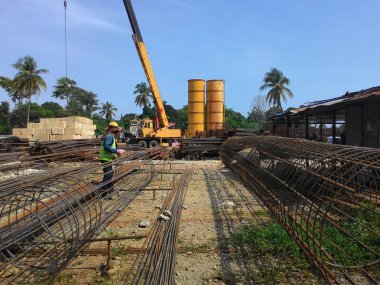 Kuala Lumpur, Malezya - 4 Ağustos 2017: İnşaat alanındaki çelik takviyeli bar bükme alanında çalışan inşaat işçileri. Bükme makinesini kullanarak demiri bükmek. 