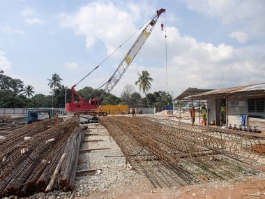 Kuala Lumpur, Malezya - 4 Ağustos 2017: İnşaat alanındaki çelik takviyeli bar bükme alanında çalışan inşaat işçileri. Bükme makinesini kullanarak demiri bükmek. 