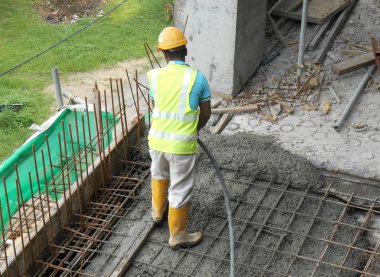 Kuala Lumpur, Malezya - 18 Mayıs 2017: İnşaat işçileri inşaat alanında yere dökülen ıslak betonu düzleştirdiler. 