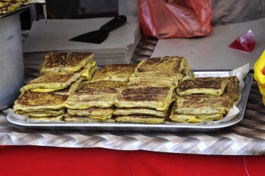 Murtabak adında bir Malezya sokak yemeği. Hawkers 'dan Cook. İçinde et, yumurta ve soğan karışımı var. Özel bir sosla yenmiş..