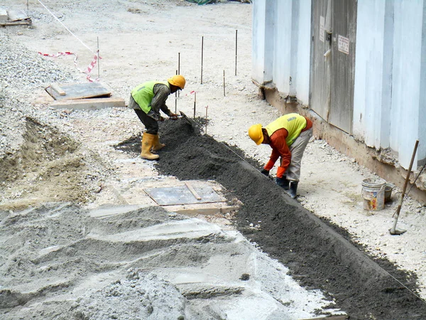 Kuala Lumpur, Malezya -3 Mayıs 2017: İnşaat işçileri inşaat alanında beton kaldırım oluşturuyorlar. Standart metal kalıbı kullanarak situ metodunu kullanıyorlar.. 