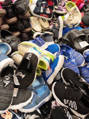 Kuala Lumpur, Malezya -02 Mayıs 2018: Farklı türde ayakkabı ve terlikler bir yerde yığılıp müşterilere satılıyor. Çeşitli marka, tasarım ve boyutlarda satılıyor..