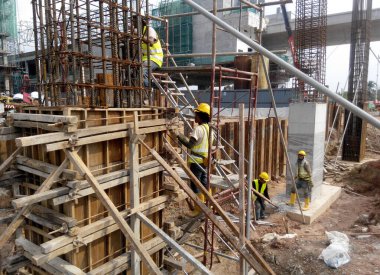 Malacca, Malezya - 29 Temmuz 2016: Malezya 'nın Malezya kentindeki inşaat alanında sütun kerestesi ve takviye barı üreten inşaat işçileri. 