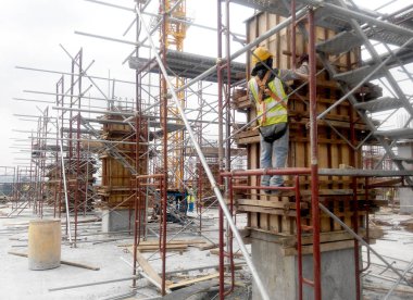 Malacca, Malezya - 29 Temmuz 2016: Malezya 'nın Malezya kentindeki inşaat alanında sütun kerestesi ve takviye barı üreten inşaat işçileri. 