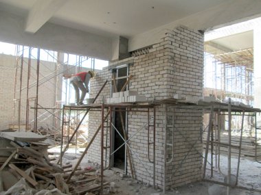 Johor, Malezya - 25 Kasım 2016: İnşaat alanında inşaat duvarları oluşturmak için tuğla döşeyen tuğla ustası. 