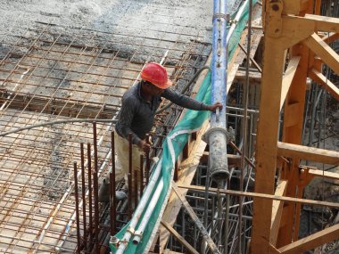 KUALA LUMPUR, MALAYSIA - 16 Mayıs 2017: İnşaat işçileri inşaat alanındaki kereste formuna beton pompa kullanarak ıslak beton döken bir grup işçi.  