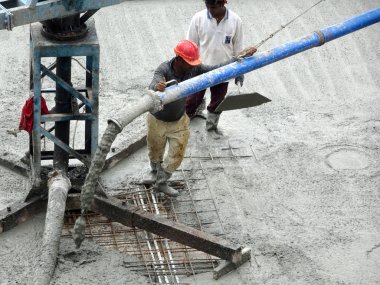KUALA LUMPUR, MALAYSIA - 16 Mayıs 2017: İnşaat işçileri inşaat alanındaki kereste formuna beton pompa kullanarak ıslak beton döken bir grup işçi.  