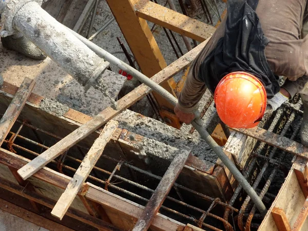 KUALA LUMPUR, MALAYSIA - 16 Mayıs 2017: İnşaat işçileri inşaat alanındaki kereste formuna beton pompa kullanarak ıslak beton döken bir grup işçi.  