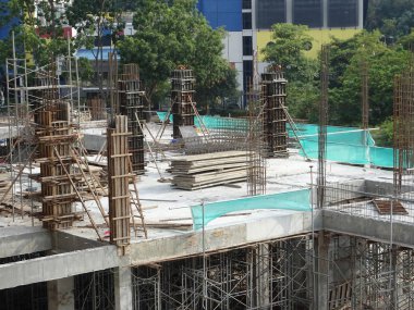 Çelik takviyeli beton kolon yapım aşamasında. İnşaat alanındaki yapının bir parçası olarak. Sütunun üstündeki takviye çubuğu inşaatın bir sonraki aşaması için hazır..