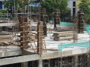 Çelik takviyeli beton kolon yapım aşamasında. İnşaat alanındaki yapının bir parçası olarak. Sütunun üstündeki takviye çubuğu inşaatın bir sonraki aşaması için hazır..