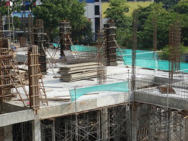 Çelik takviyeli beton kolon yapım aşamasında. İnşaat alanındaki yapının bir parçası olarak. Sütunun üstündeki takviye çubuğu inşaatın bir sonraki aşaması için hazır..