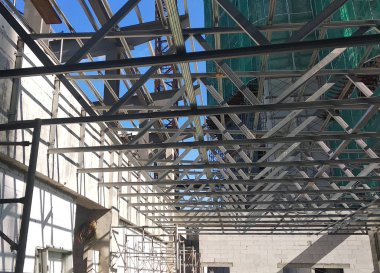 Kuala Lumpur, Malezya - 16 Haziran 2019: İnşaat alanında hafif çatı kirişleri inşa ediliyor. Çatı kaplama sistemini almak için işçiler tarafından düzgünce yerleştirilmiş. 