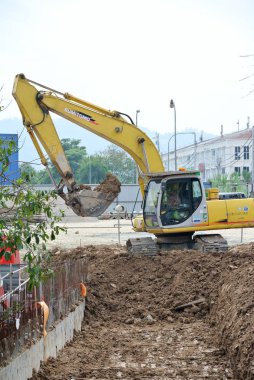 Selangor, Malezya - 08 Ağustos 2016: Kazı makinesi, inşaatta kazı toprağı kullanılan ağır bir inşaat makinesidir. Kovayla uzun hidrolik kolla güçlendirilmiş. İşçiler tarafından işletiliyor. 