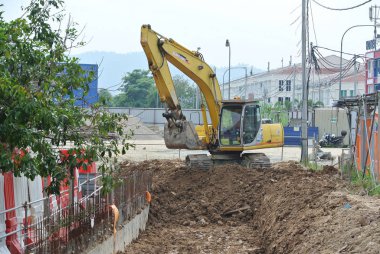 Selangor, Malezya - 08 Ağustos 2016: Kazı makinesi, inşaatta kazı toprağı kullanılan ağır bir inşaat makinesidir. Kovayla uzun hidrolik kolla güçlendirilmiş. İşçiler tarafından işletiliyor. 