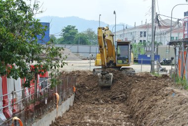 Selangor, Malezya - 08 Ağustos 2016: Kazı makinesi, inşaatta kazı toprağı kullanılan ağır bir inşaat makinesidir. Kovayla uzun hidrolik kolla güçlendirilmiş. İşçiler tarafından işletiliyor. 