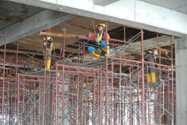 Perak, Malezya-18 Temmuz 2016: emniyet kemeri takıyor ve İskele yüksek düzeyde inşaat sitesine yükleme inşaat işçileri. 